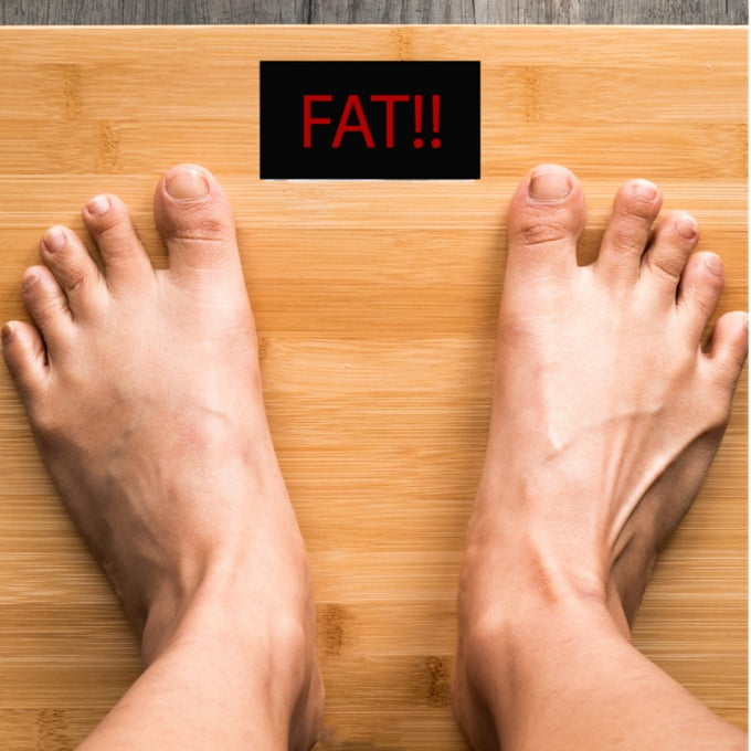 A weighing machine showing “FAT!!”